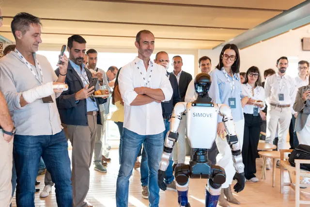 Demostración de un robot humanoide con asistentes al encuentro